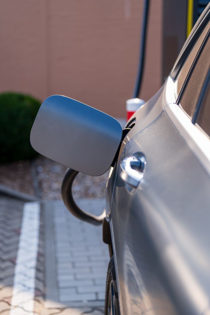 Close-up of an electric car being charged at a station. Sustainability and green technology.