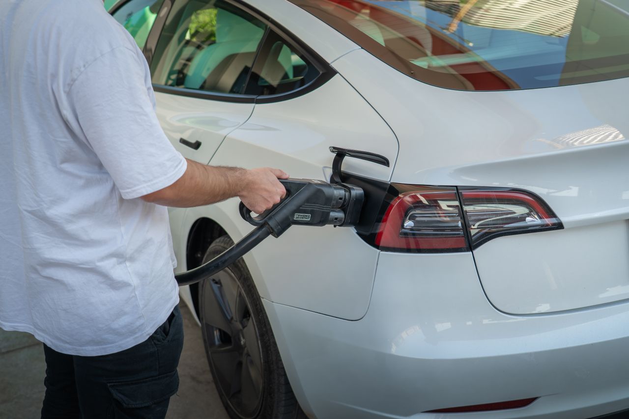 Electric car being charged at a station, highlighting eco-friendly transportation.