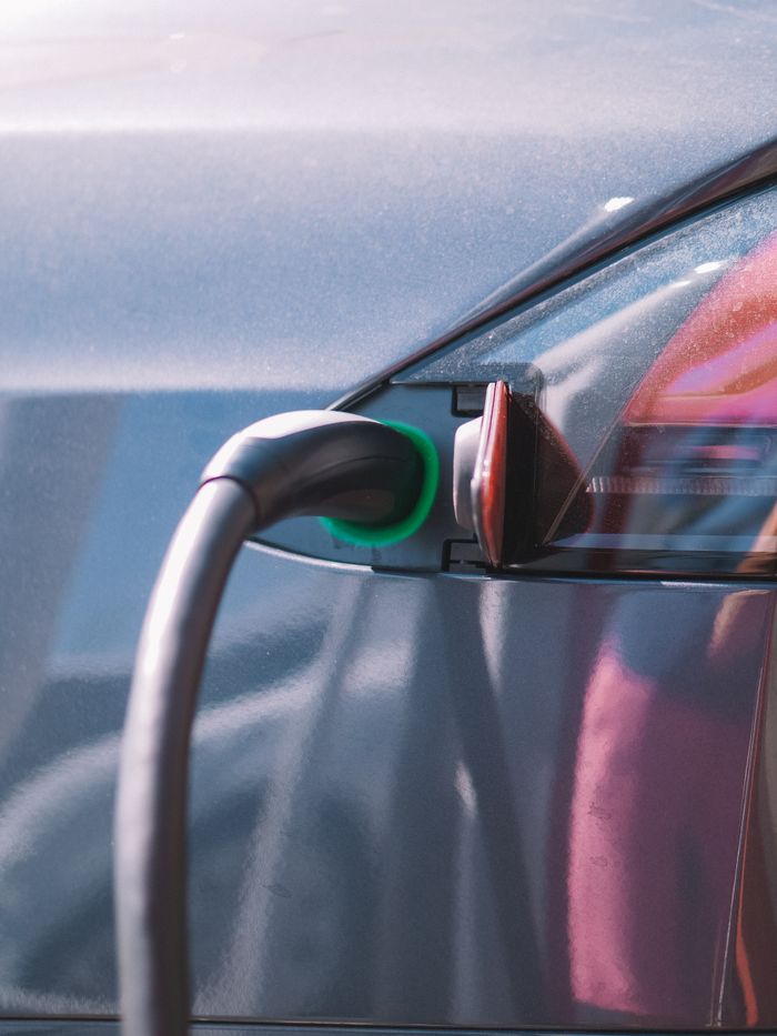 Close-up of an electric car plugged into a charging station, showcasing modern technology.